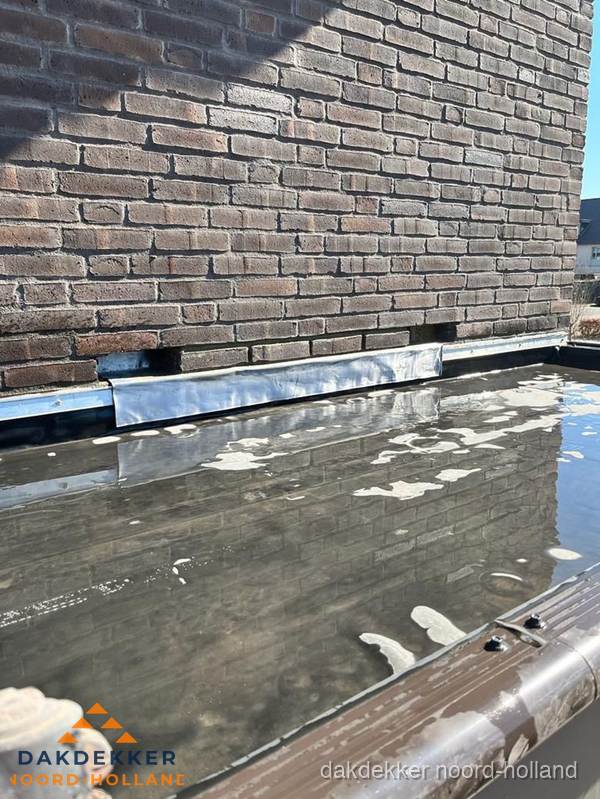 Stilstaand water op plat dak door slechte afwatering in Noord-Holland Stilstaand water op plat dak door slechte afwatering in Noord-Holland