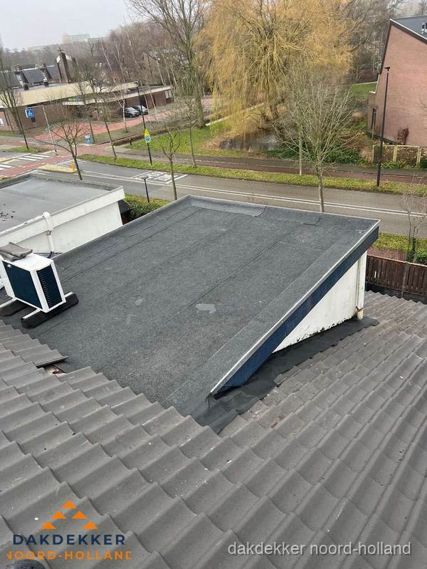 Plat dak met bitumen dakbedekking naast schuin pannendak in Noord-Holland Plat dak met bitumen dakbedekking naast schuin pannendak in Noord-Holland