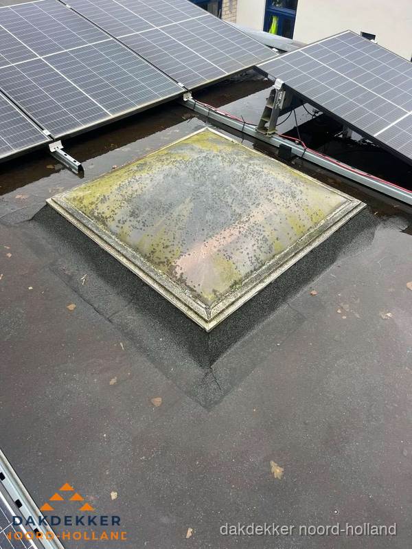 Vervuilde lichtkoepel op plat dak met zonnepanelen in Noord-Holland Vervuilde lichtkoepel op plat dak met zonnepanelen in Noord-Holland